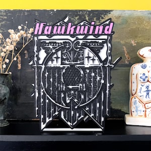 Könnte beinhalten: Schwarz-weißes 3D-gedrucktes Wandbild mit dem Wort "Fauxkind" in pinken Buchstaben oben. Das Design zeigt ein kreisförmiges Muster mit komplizierten Details.