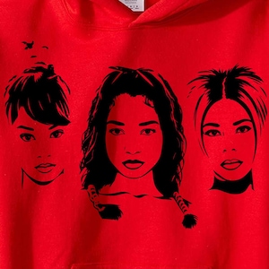 Op de afbeelding: Een felrode hoodie met een zwarte grafische print van drie verschillende gezichten horizontaal op de borst. Het kledingstuk is voorzien van een capuchon met trekkoord en een kangoeroezak, met een wit Gildan-label in de nek.
