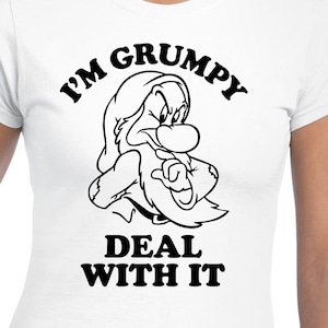 Puede incluir: Camiseta blanca con un gráfico negro de Gruñón de Blancanieves, con el texto "I'M GRUMPY DEAL WITH IT". El personaje de dibujos animados se representa con una expresión seria y un dedo señalando.