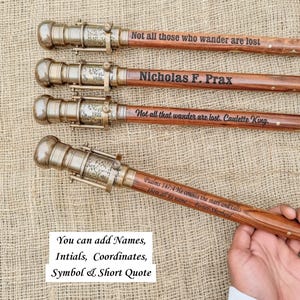 May include: Four wooden walking sticks with brass-colored metal detailing. Each stick has a unique engraved quote or name. One stick reads "Not all those who wander are lost." Another says "Nicholas F. Prax." The image also includes text: "You can add Names, Intials, Coordinates, Symbol & Short Quote."