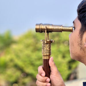 A person using the telescope cane outdoors, demonstrating its functional spyglass feature.