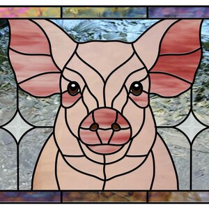 May include: Stained glass panel featuring a pig's face. The pig is depicted in shades of pink and brown, with large ears and a prominent snout. The panel is framed with a dark border and includes decorative star-shaped elements.