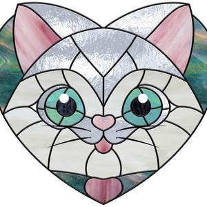 May include: Stained glass cat face in a heart shape. The cat has large, teal eyes, a pink nose, and pink ears. The glass is a mix of white, silver, pink, and teal, with black lines defining the design. The overall shape is a heart.