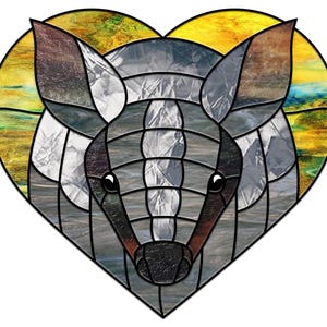 Könnte beinhalten: Ein herzförmiges Design aus Buntglas mit einem grauen Gürteltier mit gelben und blauen Akzenten.