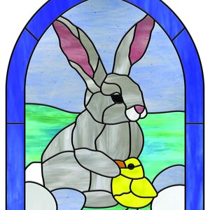 May include: Stained glass panel featuring a gray rabbit with pink-lined ears and a yellow chick. The rabbit is holding the chick, with a blue and green background. The panel is framed in a blue border, creating a decorative Easter theme.