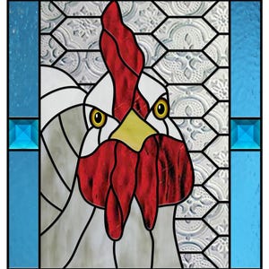 Può includere: Una finestra in vetro colorato che raffigura la testa di un gallo con cresta e bargigli rossi, piume bianche e occhi gialli. Lo sfondo è un motivo geometrico blu e bianco.