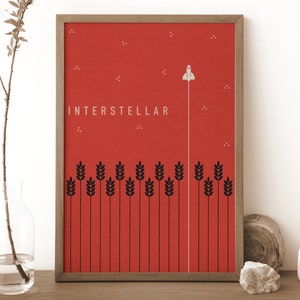 May include: A framed print with a red background and black wheat stalks. The print features a white rocket ship flying upwards with the word "INTERSTELLAR" in white text.