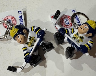 J.F. Sports - Par de llaveros de hockey Lil' Brat de los Michigan Wolverines
