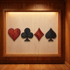 Op de afbeelding: Houten wandkunst met de vier kleuren van speelkaarten: harten, klaveren, ruiten en schoppen. Elke kleur heeft een andere kleur: rood, zwart en donkerrood. De kunst is ingelijst in een houten lijst en geplaatst tegen een lichte houten achtergrond.