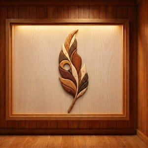 Op de afbeelding: Houten veermuurkunst met verschillende bruintinten. De veer is gemonteerd op een lichtgekleurde houten achtergrond binnen een houten frame. De veer heeft een uitgesneden cirkel en is genummerd.