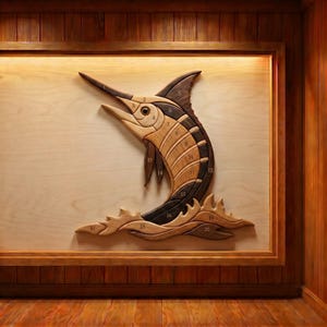以下が含まれることがあります： 木製のカジキの壁掛けアート。このアートワークは、さまざまな木の色合いで作られたカジキの魚の詳細な描写を特徴としています。魚は明るい色の木の背景に取り付けられ、より暗い木のボーダーで縁取られています。
