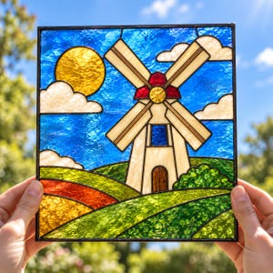 Könnte beinhalten: Ein quadratisches Buntglasfenster mit einer Windmühle mit cremefarbenen Wänden und braunen Flügeln vor einem hellblauen Himmel mit weißen Wolken und einer gelben Sonne. Im Vordergrund sind grüne Hügel mit orangefarbenen und gelben Akzenten zu sehen.
