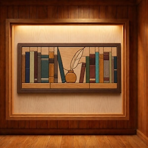 May include: A rectangular wooden wall art piece featuring a stylized bookshelf design. The artwork displays various vertical book shapes in shades of blue, green, brown, and tan, with a central inkwell and quill pen motif set within a dark frame.