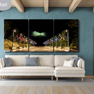 May include: A three-panel canvas print of a nighttime street scene with flags and streetlights. The print is 40 inches wide by 90 inches tall and is displayed on a white couch in a living room.