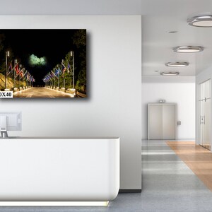 May include: A night time photo of a street lined with lampposts and flags. The flags are a variety of colors and designs. The street is empty and the lights are on. The image is 30x40 inches.