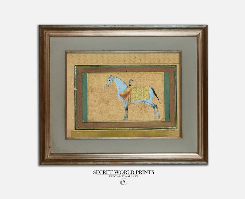 May include: A framed painting of a blue horse with a rider in a gold and red outfit. The horse is standing on a gold background with a green border. The painting is framed in a gold frame.