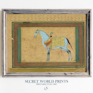May include: A framed print of a blue horse with a gold and red saddle, set against a beige background. The print is surrounded by a brown and green frame.