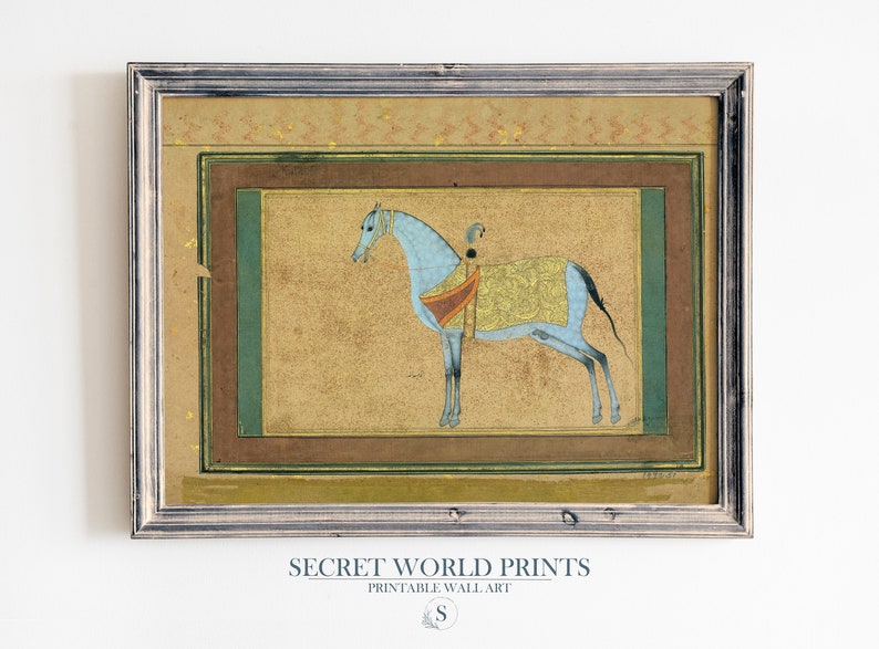 May include: A framed print of a blue horse with a gold and red saddle, set against a beige background. The print is surrounded by a brown and green frame.