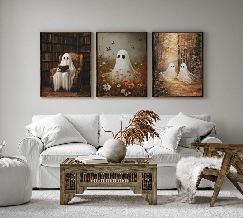 May include: Three framed paintings of ghosts in different settings. The first painting shows a ghost reading a book in a library. The second painting shows a ghost in a field of flowers. The third painting shows two ghosts walking in a forest.