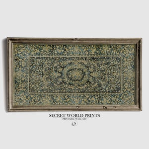 K&ouml;nnte beinhalten: Ein gerahmter Druck eines Vintage-Teppichs mit einem blauen und goldenen floralen Muster. Der Rahmen ist aus dunklem Holz mit einer abgenutzten Oberfl&auml;che. Der Druck tr&auml;gt den Titel "SECRET WORLD PRINTS" und "PRINTABLE WALL ART".