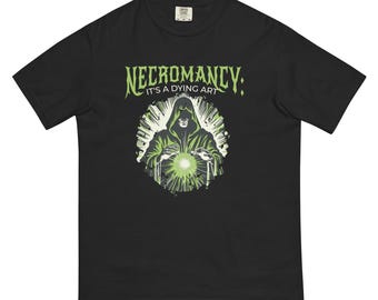 May include: Black t-shirt with a green graphic of a hooded figure holding a glowing orb. The text "Necromancy: It's a dying art" is printed above the figure.