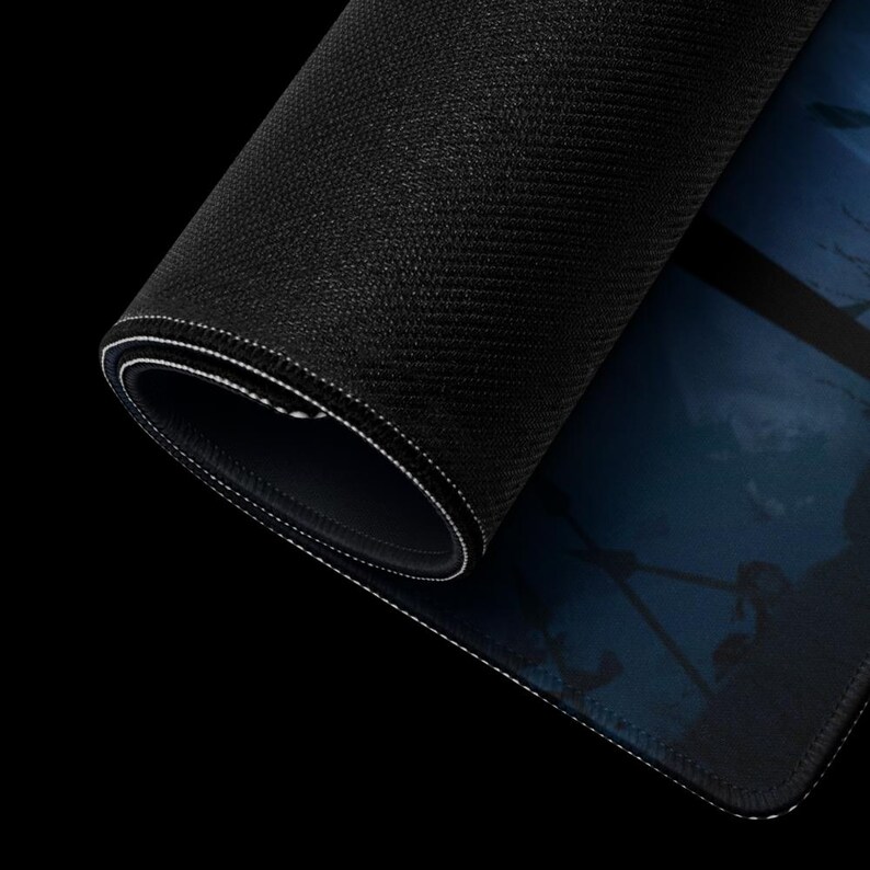 May include: A black gaming mouse pad with a blue and white design. The mouse pad is rolled up and the edge is visible.