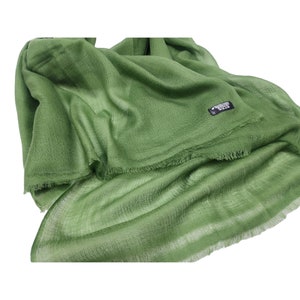Puede incluir: Un chal de pashmina verde suave con un borde con flecos. El chal está hecho de 100% cachemira y es ligero y cálido.