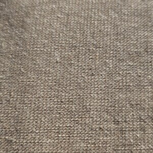 May include: Close-up of a brown woven fabric with a textured surface.