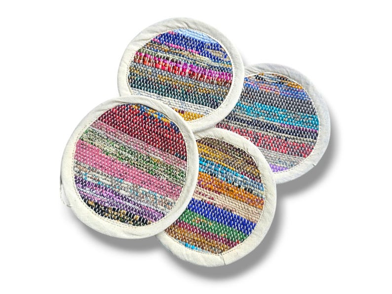 May include: Four colorful woven coasters with white fabric edging. The coasters feature a variety of colors and patterns, including pink, blue, green, yellow, and red.