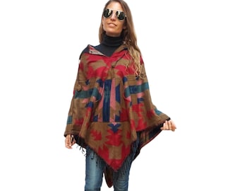 May include: A brown, red, blue, and green patterned poncho with a hood and fringe. The poncho is worn by a person with long brown hair and sunglasses.