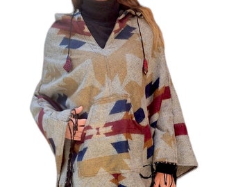 May include: A gray hooded poncho with a geometric pattern in shades of brown, blue, and red. The poncho has a large pocket on the front and fringe trim around the edges.