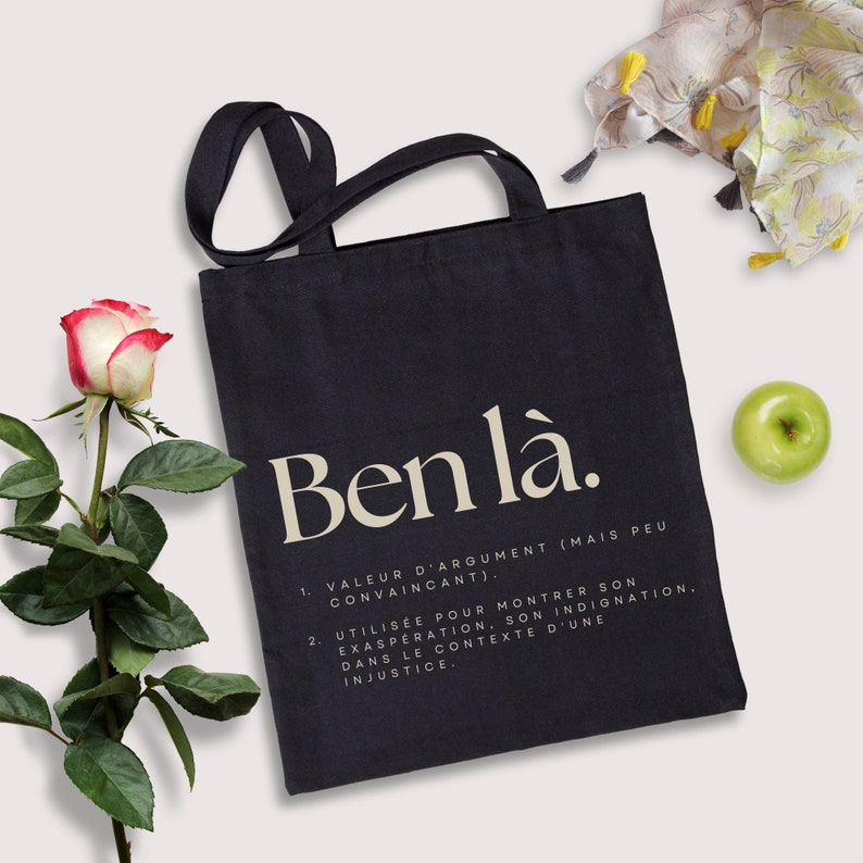 May include: Black tote bag with the text "Ben l&agrave;." and a definition of the term in French. The definition is: "1. Value of argument (but not convincing). 2. Used to show one's exasperation, one's indignation. In the context of an injustice."