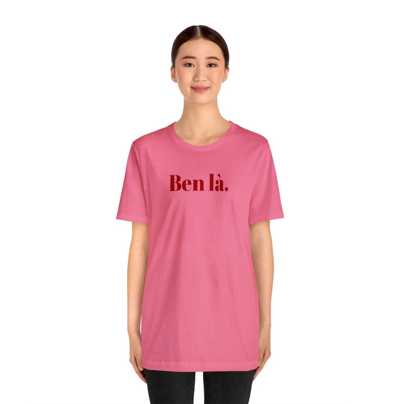 K&ouml;nnte beinhalten: Ein pinkfarbenes T-Shirt mit dem Text "Ben l&agrave;." in Rot auf der Vorderseite.