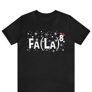 May include: Black t-shirt with a white graphic that says "FA(LA)8" with snowflakes and a Santa hat on the number 8. The shirt is a short-sleeved crew neck.