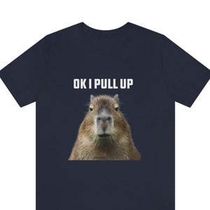 May include: A navy blue t-shirt with a capybara face and the text "OK I PULL UP" in white.