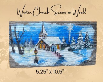 Puede incluir: Escena de iglesia de invierno pintada a mano sobre madera. La obra representa una iglesia cubierta de nieve con un campanario, rodeada de árboles y una farola. Las dimensiones son 13,3 cm x 26,7 cm. El texto "Winter Church Scene on Wood" está en la parte superior.