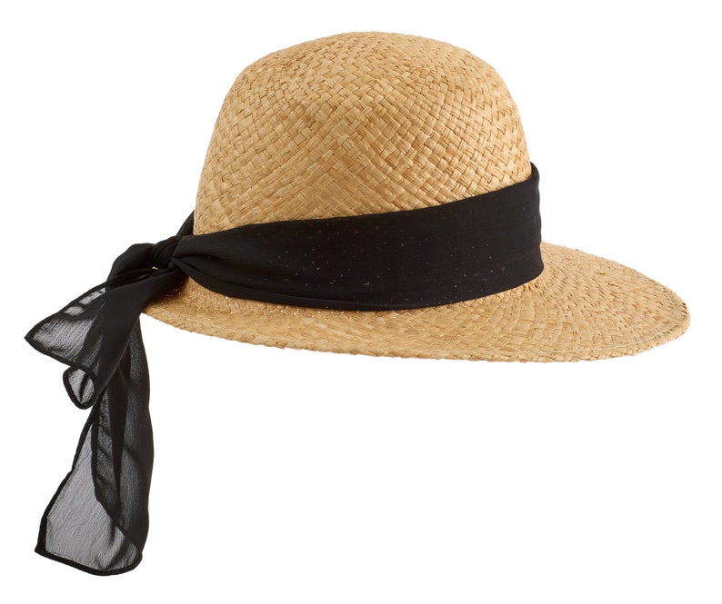 May include: A straw hat with a wide brim and a black ribbon tied around the crown. The ribbon is tied in a bow at the back of the hat.