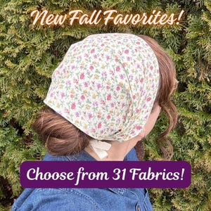 May include: A floral print headscarf featuring small pink, yellow, and green flowers on a cream background, tied with white fabric ribbons. The text New Fall Favorites! and Choose from 31 Fabrics! is overlaid on the image.