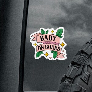 Pink banner car sign that says Baby On Board in bold letters with cute accents
