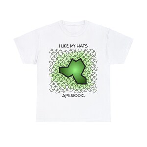 May include: White t-shirt with the text "I LIKE MY HATS" above a green hat-shaped design. The design is surrounded by a pattern of light green shapes, with the word "APERIODIC" below the design.