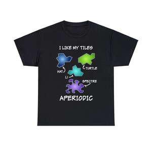 May include: Black t-shirt with a graphic design of colorful geometric shapes and the text "I like my tiles aperiodic". The shapes are labeled "Hat", "Turtle", and "Spectre".