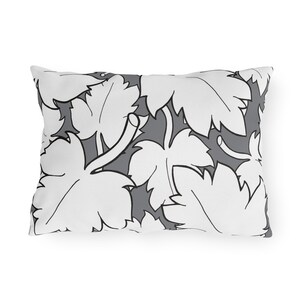 May include: A white throw pillow with a gray and white leaf pattern.