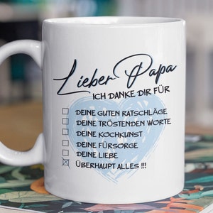 Könnte beinhalten: Weiße Keramiktasse mit einem blauen Herzen und dem Text "Lieber Papa Ich Danke Dir Für" gefolgt von einer Liste von Gründen, um einem Vater zu danken, darunter "Deine Guten Ratschläge", "Deine Tröstenden Worte", "Deine Kochkunst", "Deine Fürsorge", "Deine Liebe" und "Überhaupt Alles!!!"