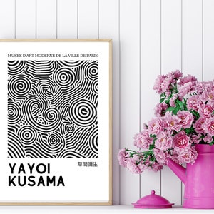 May include: A black and white poster with a swirling abstract design. The poster is framed in a light wood frame and has the text "MUSE&Eacute; D'ART MODERNE DE LA VILLE DE PARIS" at the top and "YAYOI KUSAMA" and "草間彌生" at the bottom.