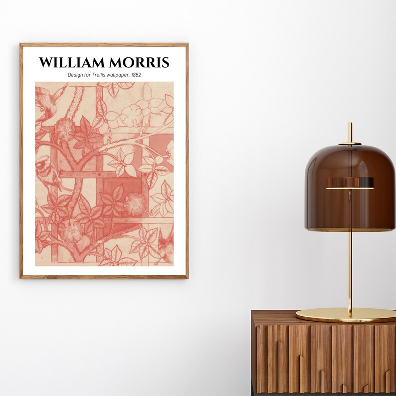 May include: A framed print of a vintage design by William Morris, titled "Trellis Wallpaper, 1862". The design features a repeating pattern of stylised flowers and birds in a red colour.