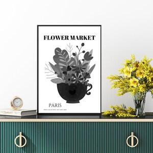 May include: A black and white poster with the text "FLOWER MARKET" and "PARIS" in a modern font. The poster features a stylized illustration of a bouquet of flowers in a black teacup.