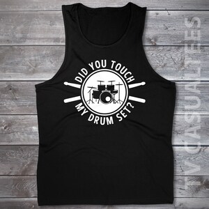 Pu&ograve; includere: Canotta nera con una grafica bianca di una batteria e il testo "Did you touch my drum set?"