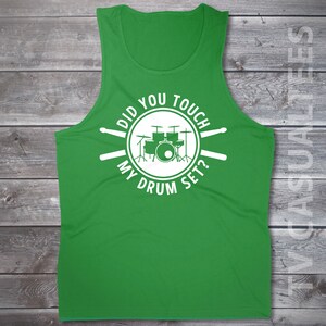 Pu&ograve; includere: Canotta verde con una grafica bianca di una batteria e il testo "Did you touch my drum set?"