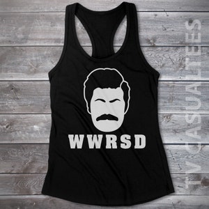 May include: Black tank top with a white graphic of a man's face with a mustache and the text "WWRSD".
