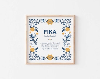 May include: A framed print with a blue and yellow floral design. The print features the word "FIKA" in bold, with the definition "(fee-ka) Swedish" and a description of the Swedish concept of "FIKA" underneath.